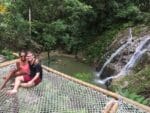 Adam and Susana sitting on a giant hammock overlooking the Marinka Waterfall, one of the best things to do when you visit Minca.