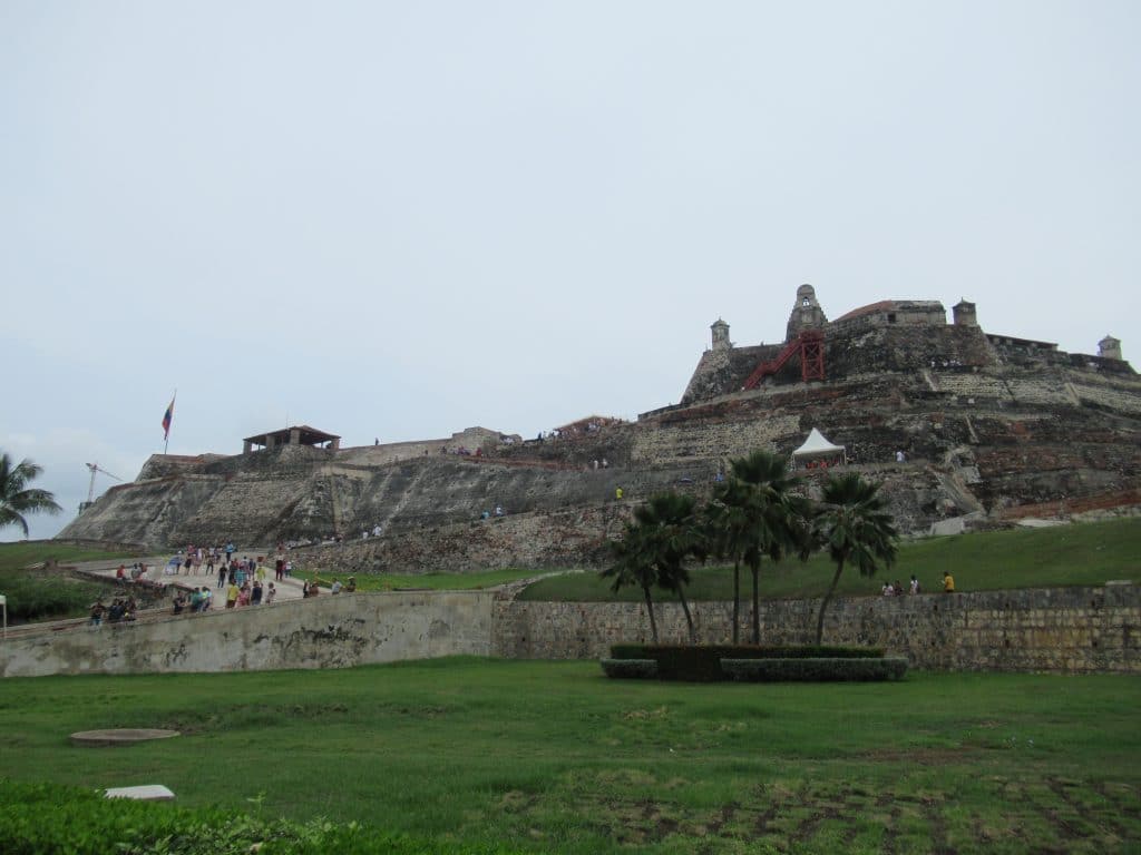 The massive San Felipe Fort in Cartagena in the background with a few palm trees in the foreground.