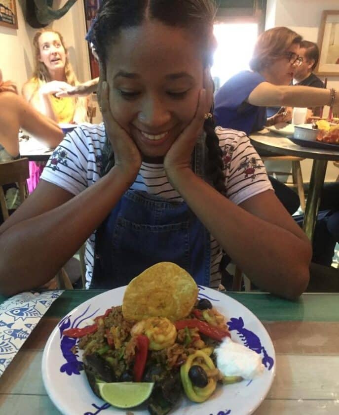 Photo of a girl looking down excitedly at a plate of seafood rice at La Cevichería Cartagena.