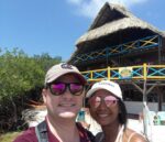 Photo of a couple standing with the Isla Roots Hostel in the background