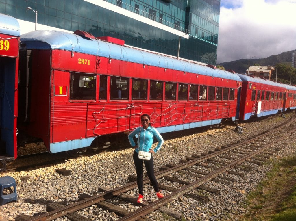 A girl standing in front of the passenger cars of the train to the Salt Cathedral of Zipaquira