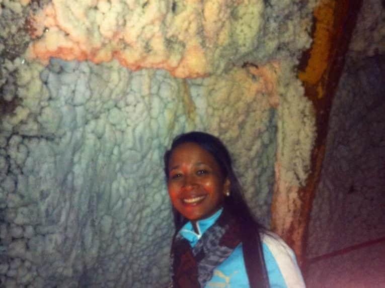 A girl standing in front of a salt formation in the salt cathedral in bogotá.