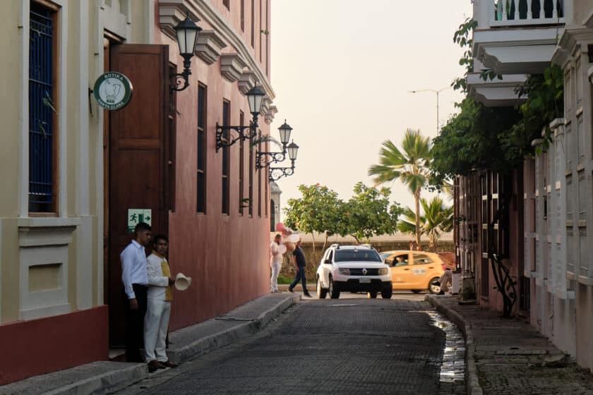 A white SUV turning down a street in front of a taxi to provide Cartagena transportation.