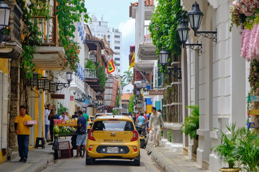 A taxi and people walking in the street looking for transportation in Cartagena, Colombia.