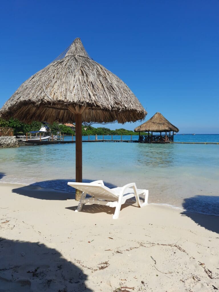 Photo of a chair under an umbrella overlooking the beach at Isla del Sol Cartagena.