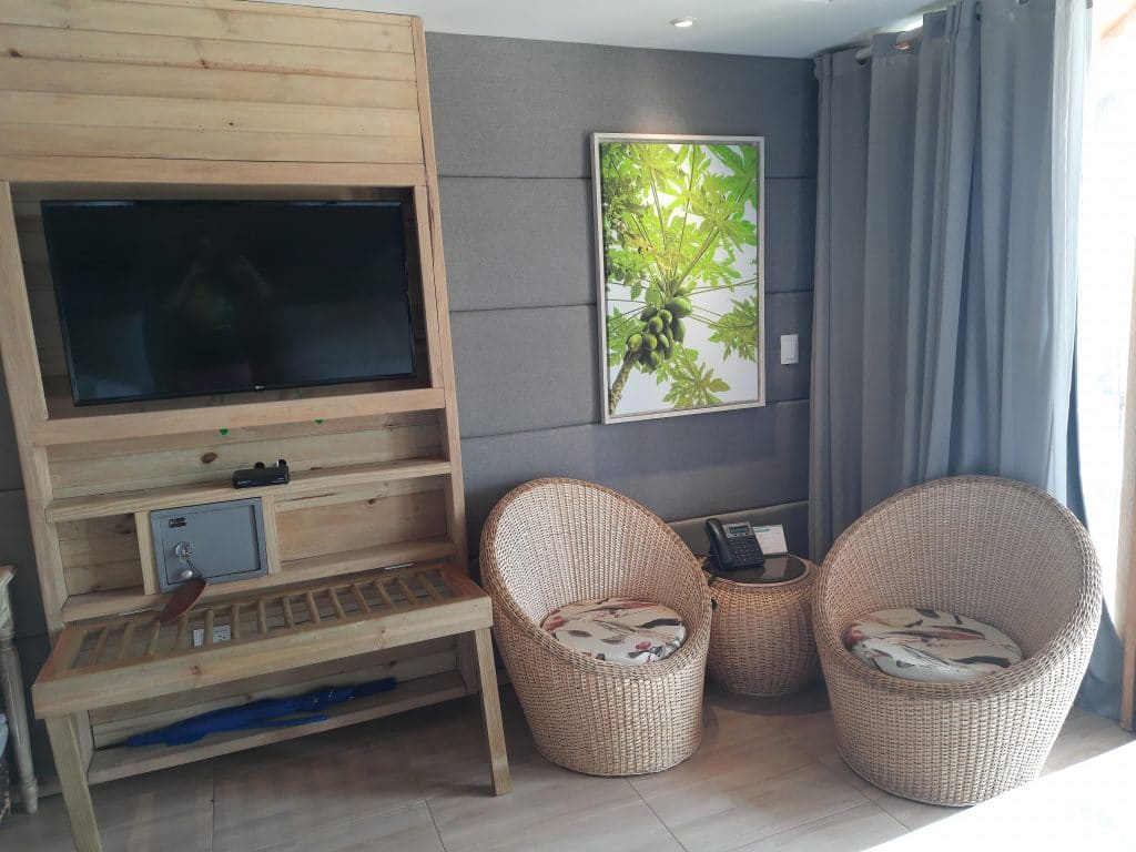 Photo of the television and two chairs with a table in the middle to the right in the room at the Barú Hotel Isla del Encanto Cartagena.