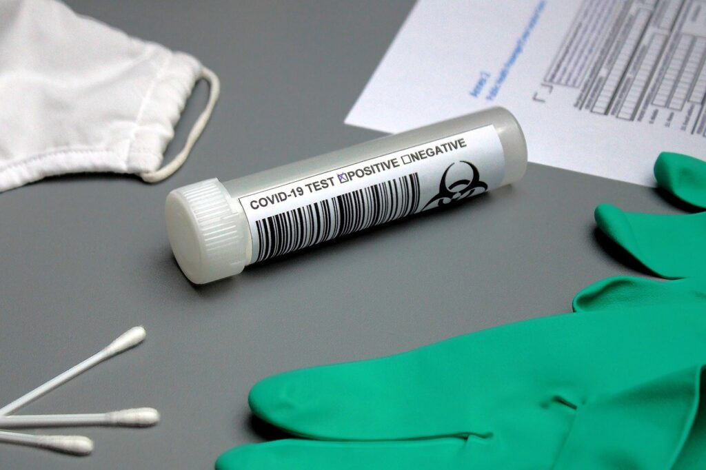 Photo of a test tube with swabs, gloves, and a form around it, like what you might see at one of the places to get a Covid test in Cartagena.