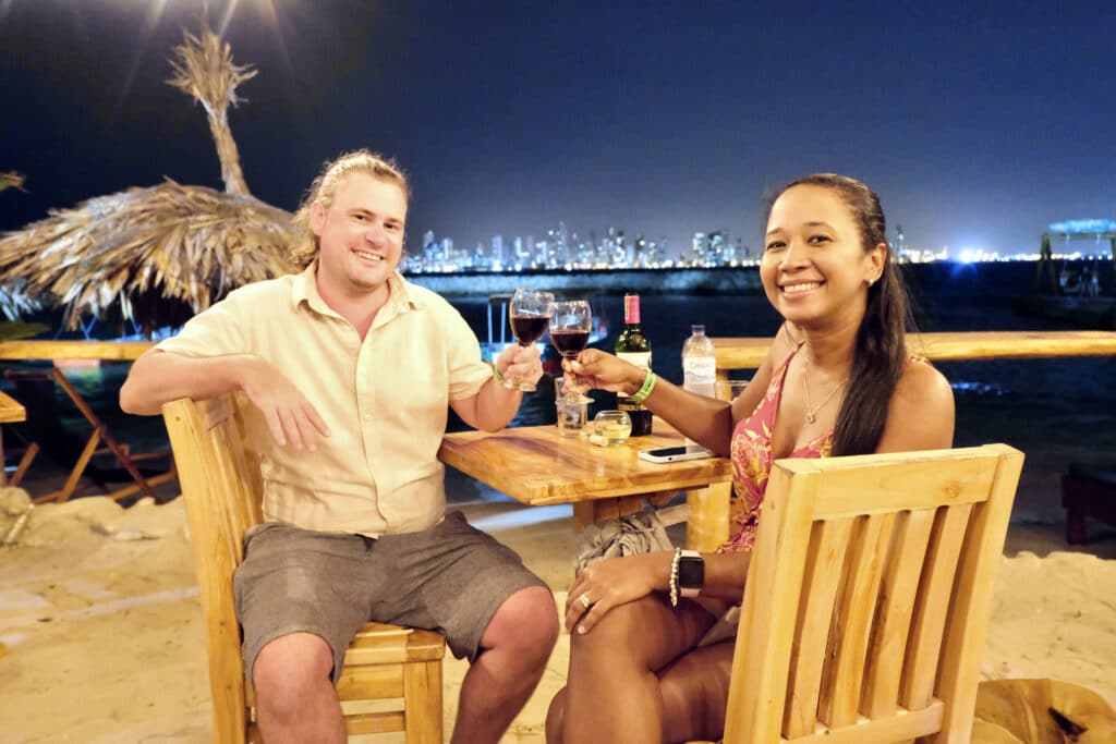 Foto de una pareja haciendo brindis en la noche en una playa de Cartagena de Indias.
