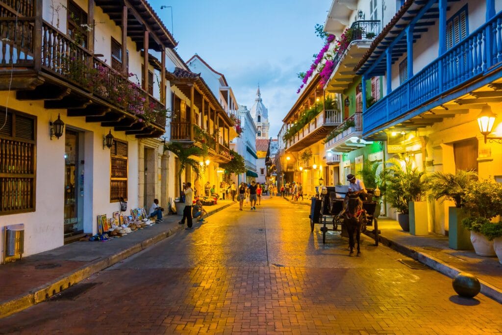 Foto de una calle con un carro de caballo y gente caminando cerca a los mejores hoteles boutique en Cartagena de Indias.