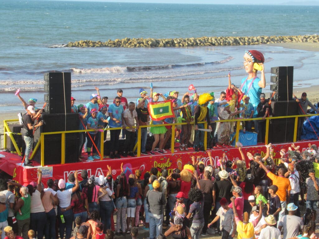 Photo of a truck with people dancing on it and the crowd in front during Cartagena Independence Day Festival.