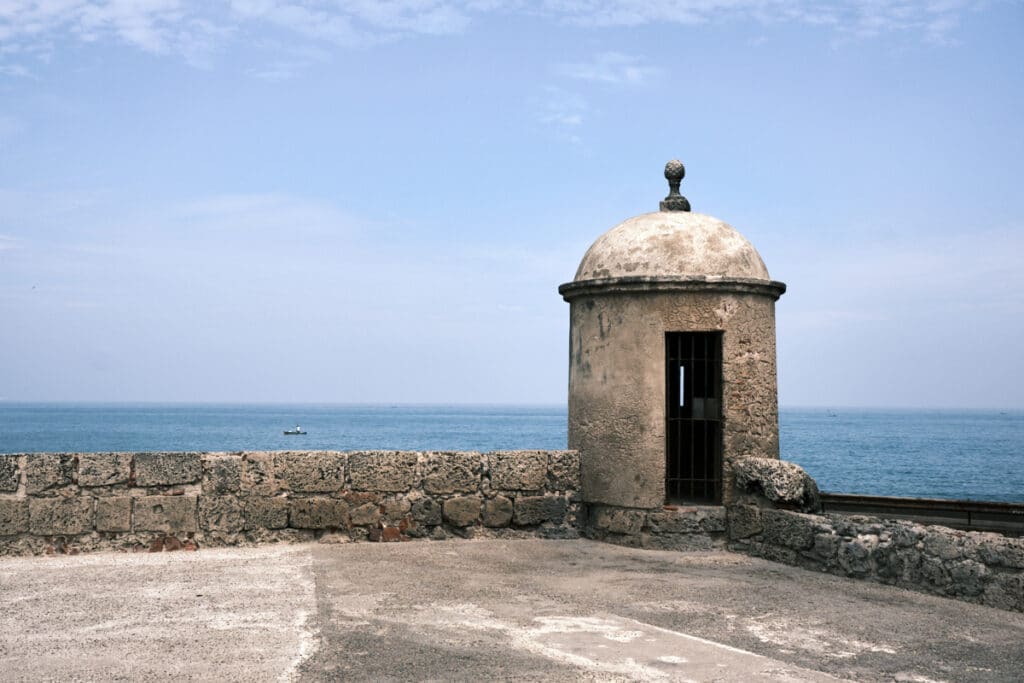 Photo of a stone watch tower in the wall of Cartagena with the sea in the background near the best Cartagena boutique hotels.
