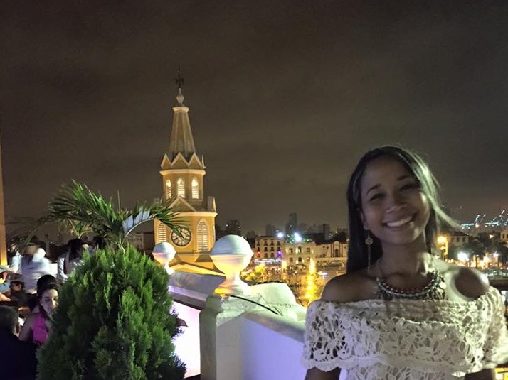 Photo of a girl with the clocktower behind her at night seeing things what to do Cartagena Colombia.