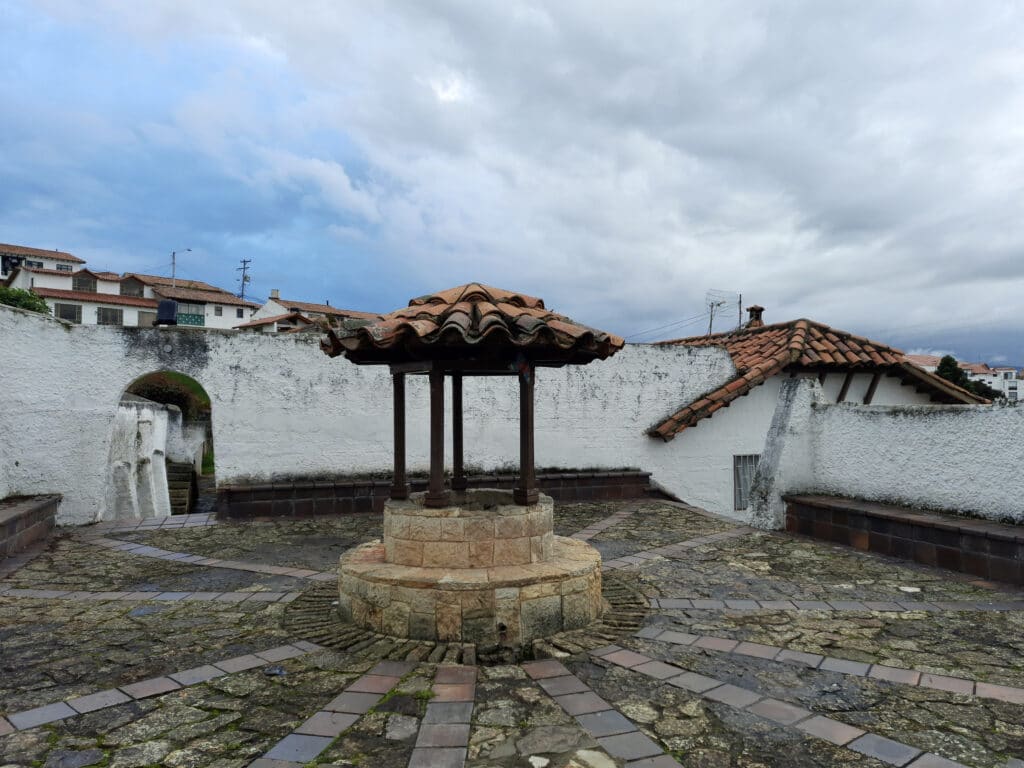 Photo of a small well in the center of a small plaza in the town of Guatavita.
