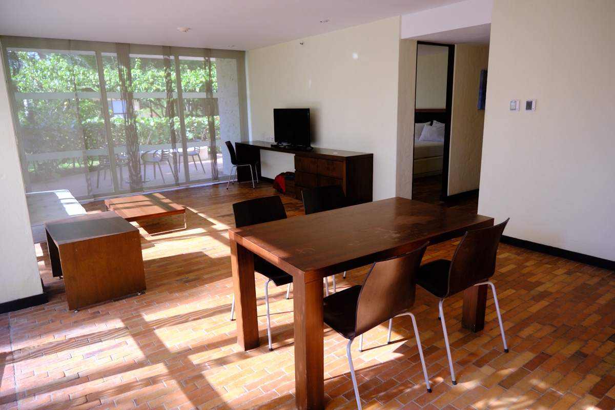 Foto de la sala de estar en una suite del estelar grand playa manzanillo con comedor, televisor y mueble.