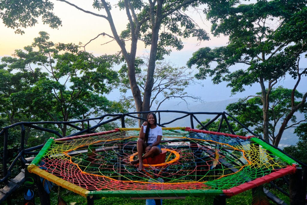Photo of a girl sitting in the middle of a giant dream catcher.
