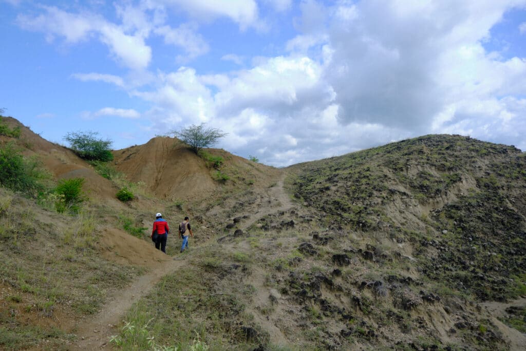 Photo of people walking on a trail up a hill during a Tatacoa Desert tour.