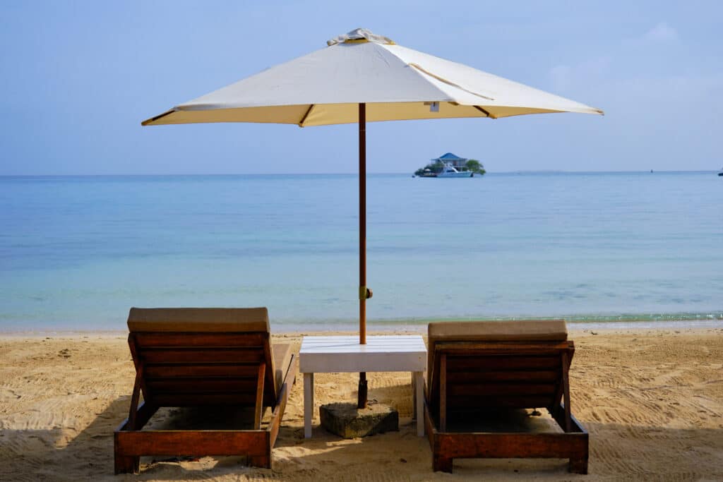 Photo of beach chairs and umbrellas on the beach at Eco Hotel IslaBela Cartagena.