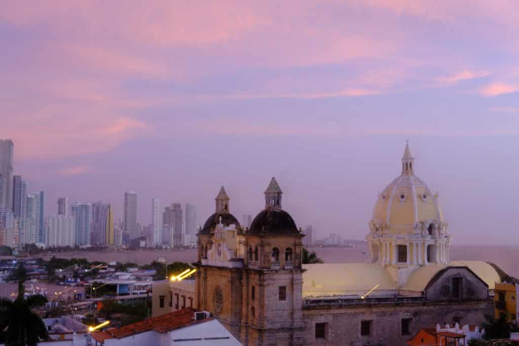 Photo of a church with tall building behind it like what you can see during Cartagena tours.