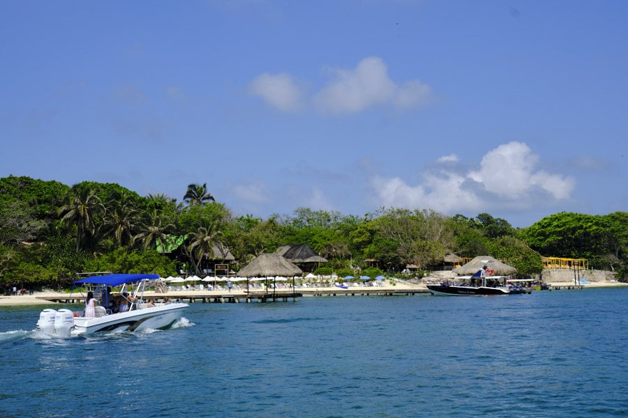 Photo of a boat approaching a dock by a beach in the Rosario Islands Colombia.