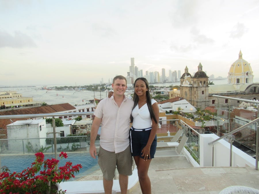 Photo of a couple in Cartagena, Colombia with the church, bay, and buildings in the background.