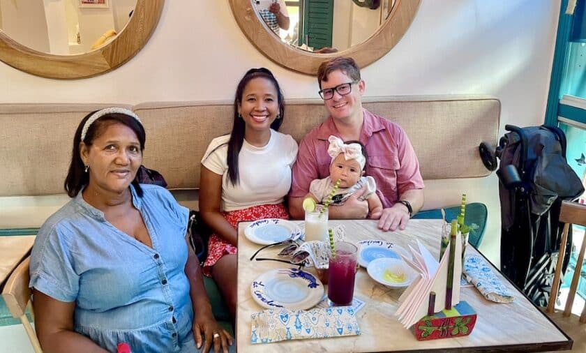 Photo of 3 adults, one holding a small  child at a table at Cartagena's La Cevichería restaurant.