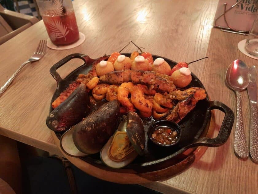 Photo of a cast iron skillet with various seafoods at Cartagena Buena Vida Restaurant.