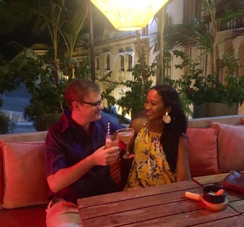 Photo of a couple doing a cheers with drinks at the rooftop bar at Buena Vida Marisquería Cartagena.