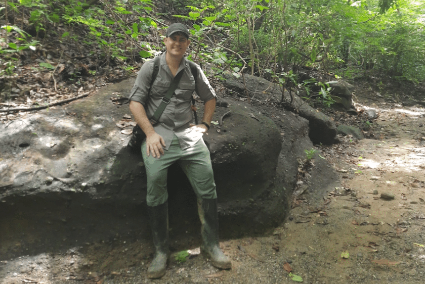 Photo of a man sitting on a rock on a Cartagena, Colombia hiking trail.