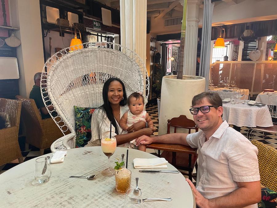 A man and woman with a woman holding a child seated at a table.