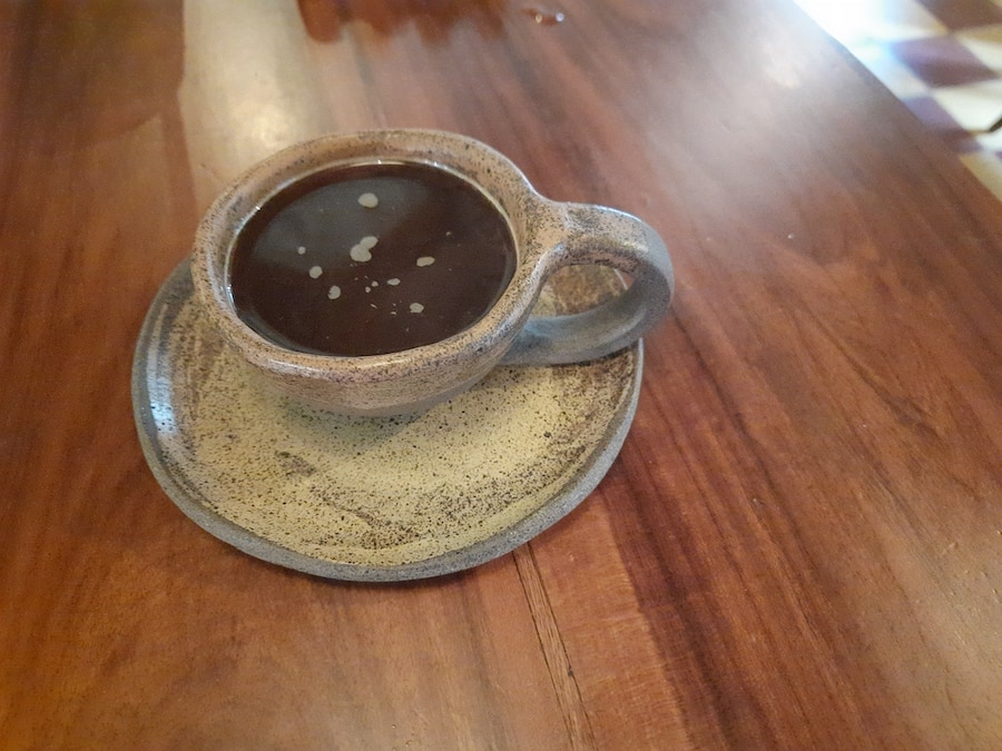A cup of coffee in a ceramic mug on a table.