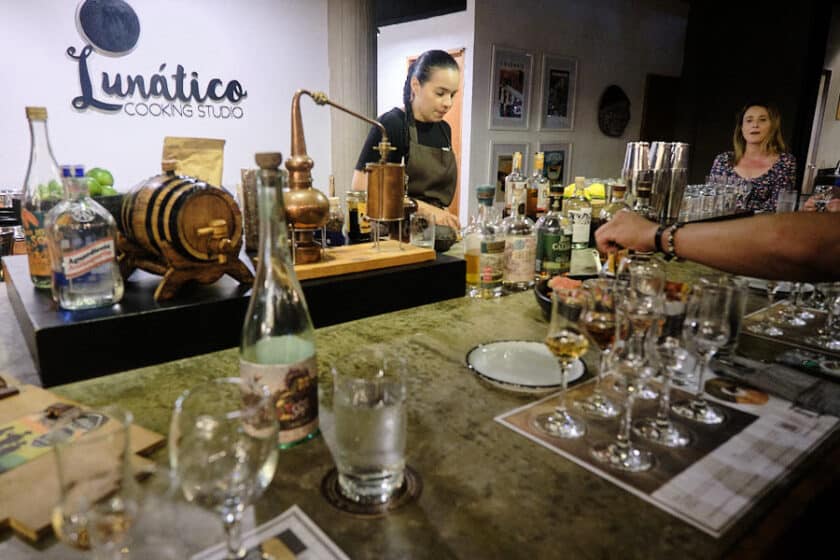 Large bar with glasses and bottles set up for a rum tasting in Cartagena and some people seated.