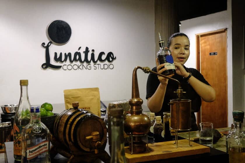 Girl holding a bottle and talking behind a bar during a Cartagena rum tasting.