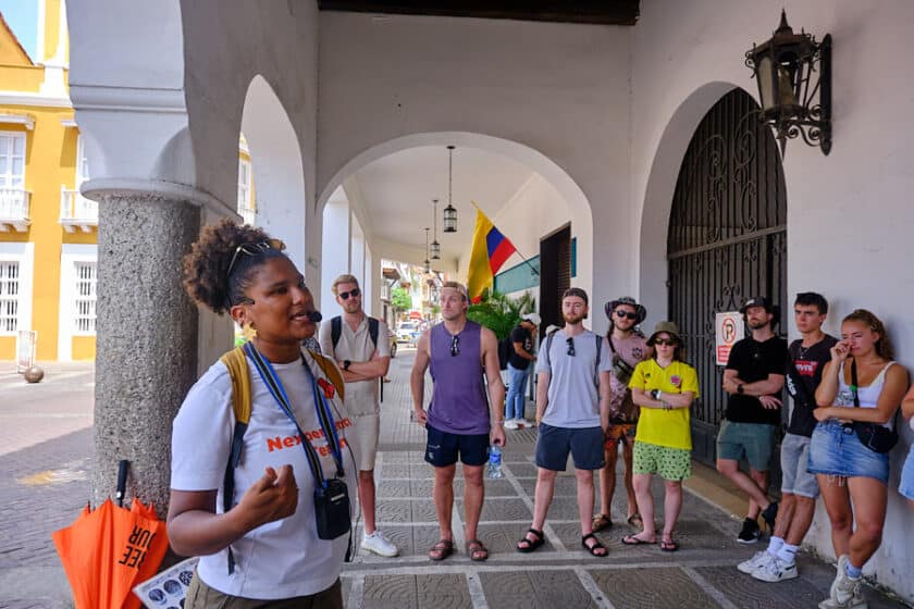 People gathered around a guide during a walking tour of Cartagena, Colombia.
