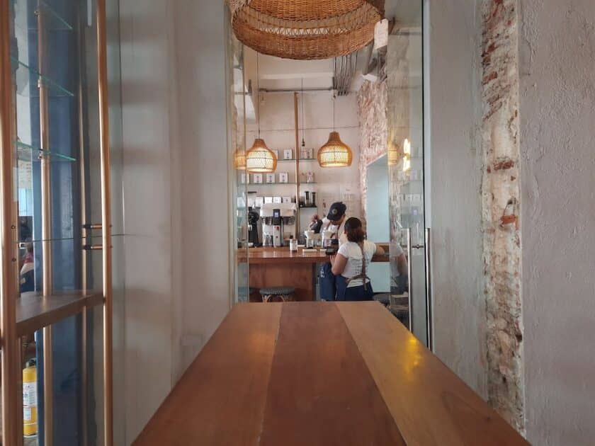 Photo of two people preparing coffee in front of a bar.