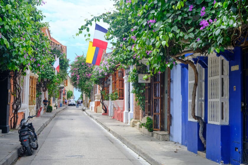 A street in Cartagena, Colombia with a motorcycle parked on the side of the road.