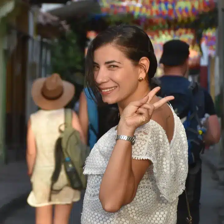 A Cartagena photographer making a peace sign in the street.