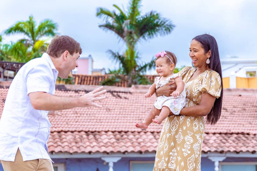Dad making funny face at baby held by mom captured by a profession photographer in Cartagena.