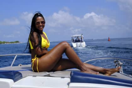 Girl sitting on front of a boat near Cartagena, Colombia.